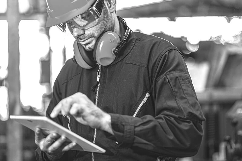 Facility manager man using iPad to track construction project progress and monitor timeline