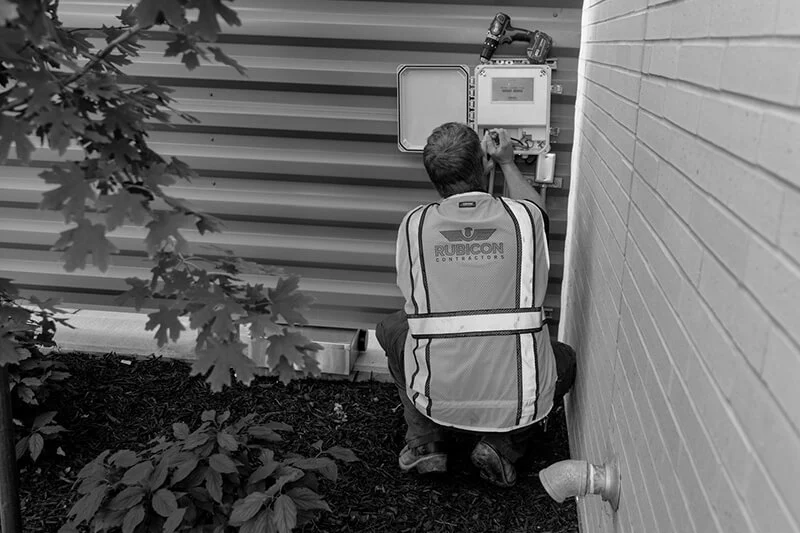 Worker installing a smart irrigation controller box