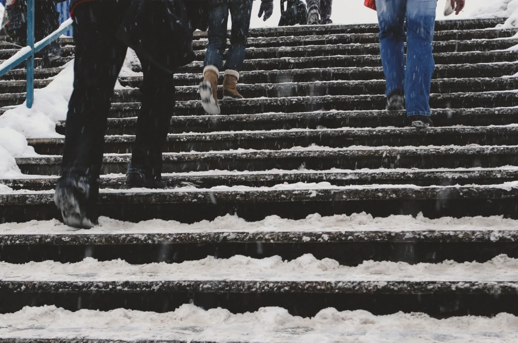 people walking up snow covered stairs